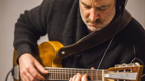 Der deutsch-armenisch-türikische Komponist Marc Sinan beim Gitarrespielen