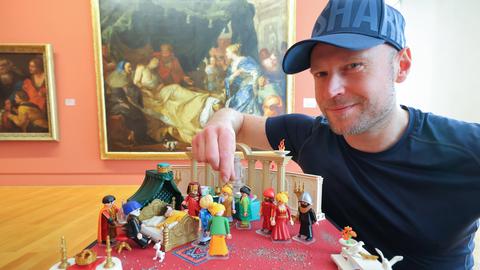 Der Künstler Oliver Schaffer ordnet Playmobil-Figuren an