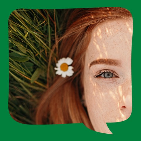 Eine junge Frau liegt auf einer Blumenwiese
