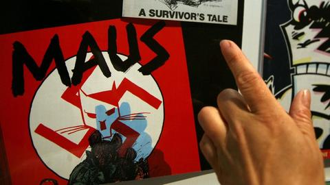 Ein Mensch schaut sich den Comic von Art Spiegelman, "Maus", an