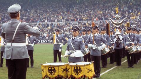 Ein Bundeswehr-Orchester spielt die Nationalhymne.