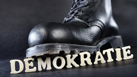 Springerstiefel tritt auf den Schriftzug "Demokratie"