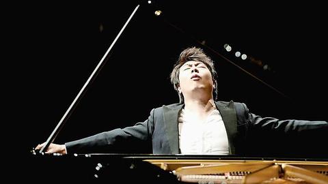 Der Pianist Lang Lang schaut nach oben und breitet die Hände aus