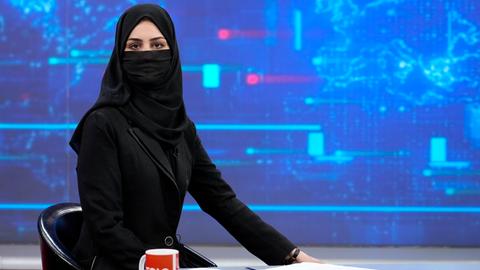 Schwarz gekleidete Frau mit einem Gesichtsschleier in einem afghanischen Fernseh-Studio.