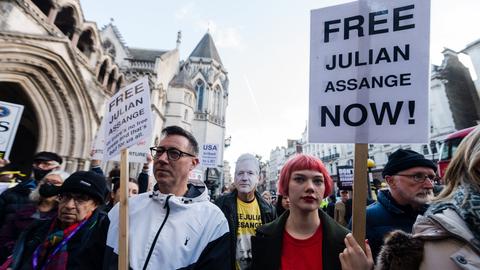 Demonstranten in London halten Schilder mit der Aufschrift "FreeJulian Assange now!"