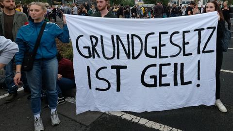  Sachsen, Chemnitz: Zuschauer stehen vor dem Konzert unter dem Motto «#wirsindmehr» auf einer Straße am Parkplatz vor der Johanniskirche und halten ein Transparent mit der Aufschrift "Grundgesetz ist geil". Bei dem Konzert wollten unter anderem Marteria und Casper, Kraftclub und die Toten Hosen auftreten. Die Bands wollen damit ein Zeichen gegen Rassismus, Ausländerfeindlichkeit und Gewalt setzen.