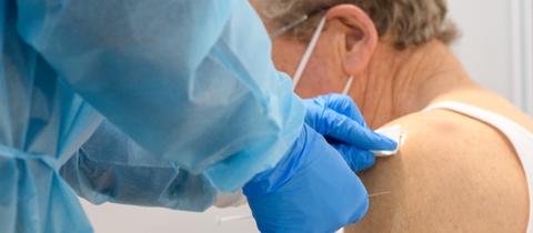 Ein Arzt verabreicht im Impfzentrum Magdeburg einem Senior eine Impfung gegen das Coronavirus. 