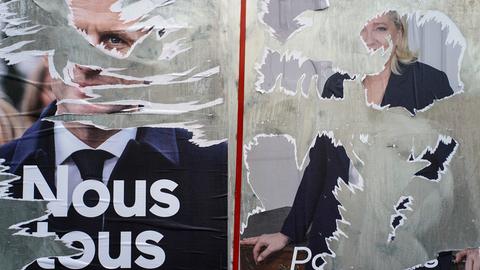 Zerrissene Wahlplakate des französischen Präsidenten Macron (l) und der rechtsextremen Präsidentschaftskandidatin Le Pen kleben an einer Wand. Der französische Präsident Macron tritt bei der Stichwahl um das Präsidentenamt am 24. April gegen die rechtsextreme Herausforderin Le Pen an.