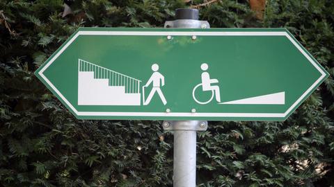 Ein Schild weist am 20.10.2008 in Frankfurt (Hessen) darauf hin, dass Fußgänger links eine Treppe und Rollstuhlfahrer rechts eine Auffahrt benutzen können. 