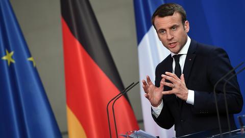 Emmanuel Macron spricht bei einer Pressekonferenz vor den Flaggen Deutschlands und Europas