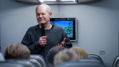 Bundeskanzler Olaf Scholz (SPD) spricht im Airbus A340 der Luftwaffe auf dem Weg nach Washington zu mitreisenden Journalisten. 