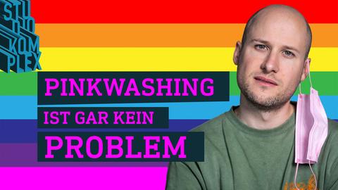 Ein Mann steht vor einem Regenbogen-farbigen Hintergrund. Darüber steht der Text: Pinkwashing ist gar kein Problem