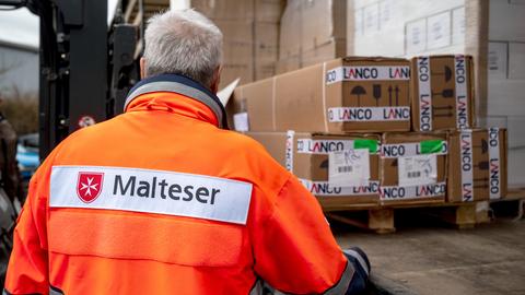 Ein Mitarbeiter des Malteser-Hilfsdiensts verlädt Hilfsgüter für die Ukraine.