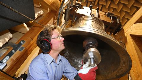 Der Glockensachverständige Michael Plitzner schlägt im Schalllabor des Europäischen Kompetenzzentrums für Glocken in Kempten eine Glocke an, um ihren Klang mit einem Mikrofon aufzunehmen und die Aufnahme danach zu analysieren.
