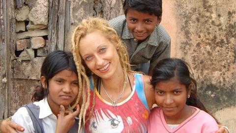 Stella Deetjen sitzt mit Waisenkindern vor einem Heim in der indischen Stadt Benares.