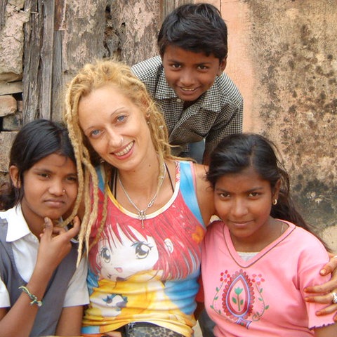 Stella Deetjen sitzt mit Waisenkindern vor einem Heim in der indischen Stadt Benares.