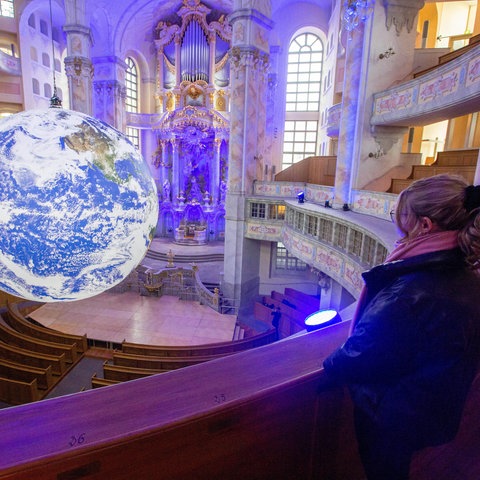 Eine Erdkugel schwebt in der Dresdner Frauenkirche.