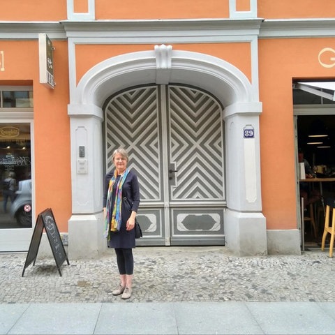 Friederike Fechner vor dem rekonstruierten Wohn- und Geschäftshaus der jüdischen Lederwarenhändler Gebrüder Blach