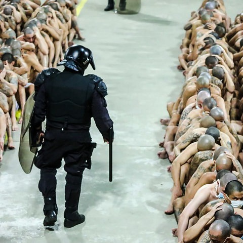 Ein Polizist überwacht zahlreiche Gefängnisinsassen.