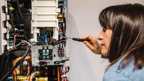 Frau repariert elektrisches Gerät