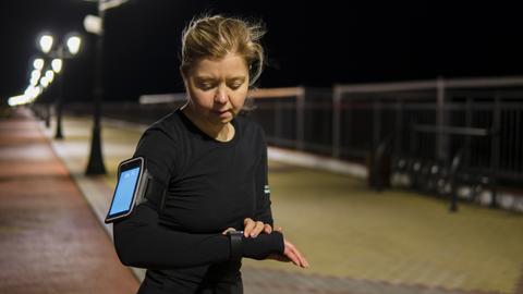Frau nutzt beim Joggen eine Smartwatch.