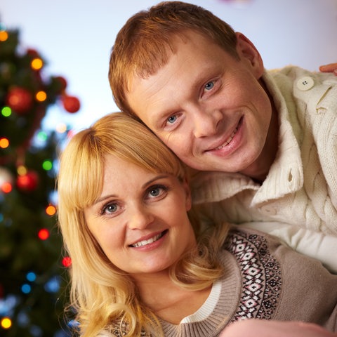Paar küsst sich unter dem Weihnachtsbaum