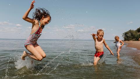 Kinder springen im Meer