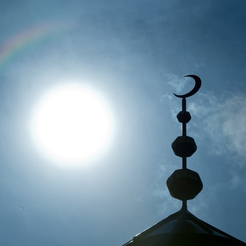 Der Halbmond auf dem Minarett der Abubakr Moschee hebt sich als Schattenriss vor der Sonne ab