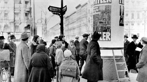 Berliner Passanten betrachten Wahlplakate zur Reichstagswahl im November 1932, bei der die NSDAP ein Drittel aller abgegebenen Stimmen errang.