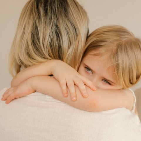 Ein Kind wird von Mutter und Großmutter getröstet