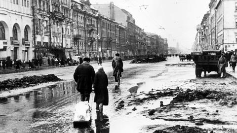 Während der Blockade von Leningrad ziehen Angehörige 1942 einen Toten entlang dem Newski-Prospekt zum Friedhof.