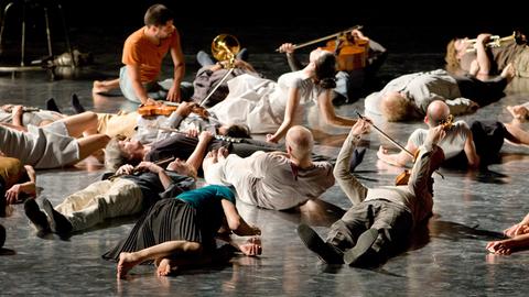 Mitglieder des "Ensemble Modern" liegen während des Festivals Frankfurter Positionen 2008 auf der Bühne.