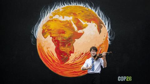 Viktor Seifert spielt Violine vor einer Wandmalerei in der St. John's Kirche, Glasgow, vor dem UN-Kimagipfel COP26.