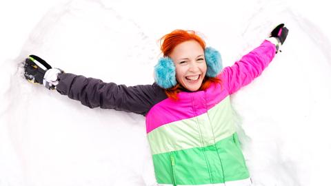 Frau mit wedelnden Armen im Schnee