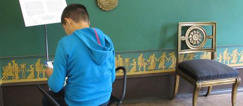 Junge liest im Goethehaus