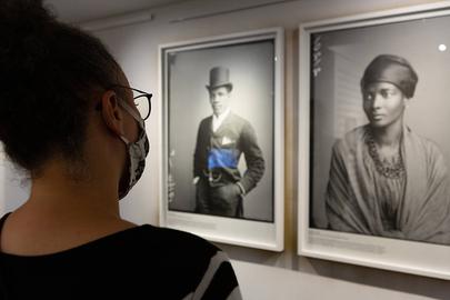 Frau betrachtet zwei Fotos in Ausstellung