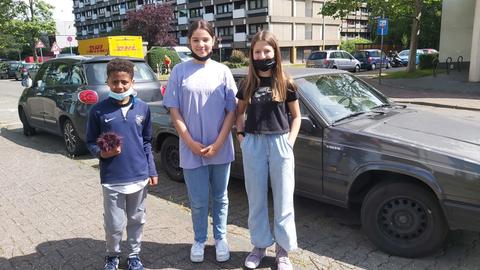 Ein Junge, zwei Mädchen stehen auf der Straße