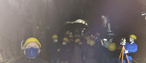 Grube von Kindern mit gelben Helmen in einem Bergwerk