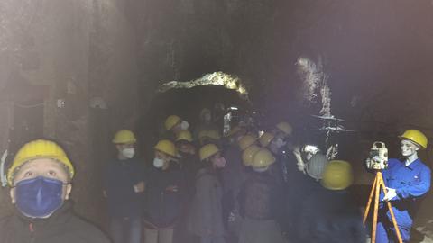 Grube von Kindern mit gelben Helmen in einem Bergwerk