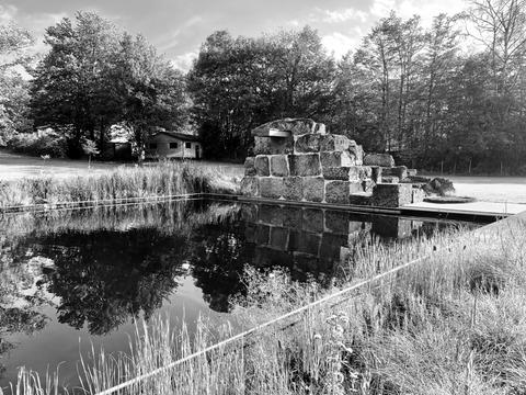 Impressionen aus dem Vogelsberg: Wasserbecken im Freien mit Natursteinmauer und darin eingearbeitetem Sprungbrett