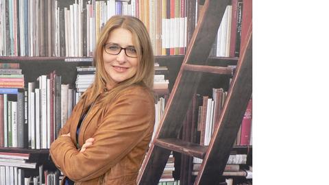 Die Schriftstellerin Luisa Sturm vor einer Bücherwand