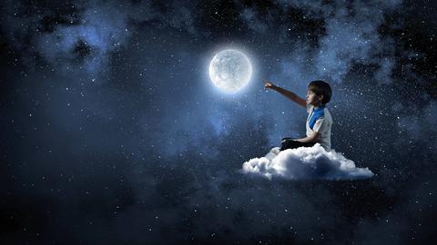 Kind greift nach dem Mond