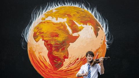 Viktor Seifert, Komponist und Violinist (St Mary's Musikschule), spielt vor einer Wandmalerei in der St. John's Kirche vor dem UN-Klimagipfel COP26, Glasgow 2021