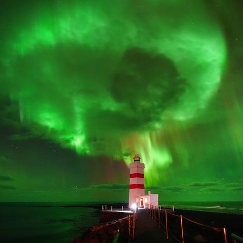Polarlichter sind über dem alten Gardur-Leuchtturm an der Nordspitze der Halbinsel Reykjanes in Island zu sehen.