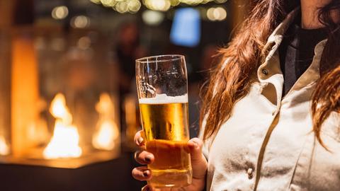 Frau hält Bierglas