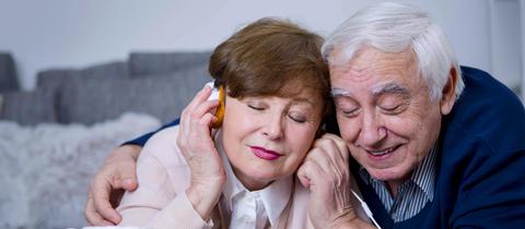 Älteres Paar hört gemeinsam über Kopfhörer