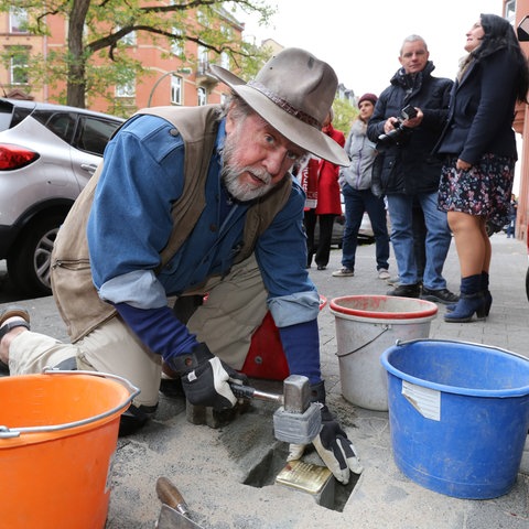 Der Künstler Gunter Demnig verlegt in Frankfurt einen Stolperstein.