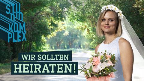 Hostess Anne trägt ein Hochzeitskleid und strahlt in die Kamera. Sie steht auf einem lichtdurchfluteten sommerlichen Parkweg umringt von Bäumen