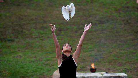 Eine Darstellerin lässt bei der Generalprobe für das Entzünden des Olympischen Feuers im antiken Olympia, dem Geburtsort der antiken Olympischen Spiele, eine weiße Taube frei. 