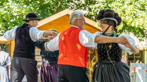 Eine Volkstanzgruppe tanzt in Schwarzwälder Tracht.